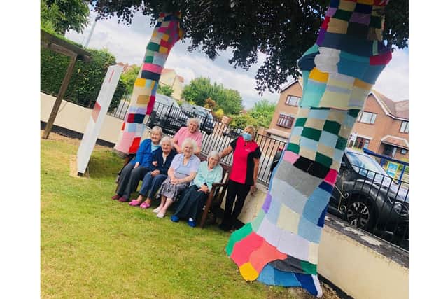 Residents at Alexandra Rose care home in Farlington have been creating 'yarn bombs' to cover trees in the garden during lockdown. Pictured: The group of knitters with activity coordinator Caroline Good
