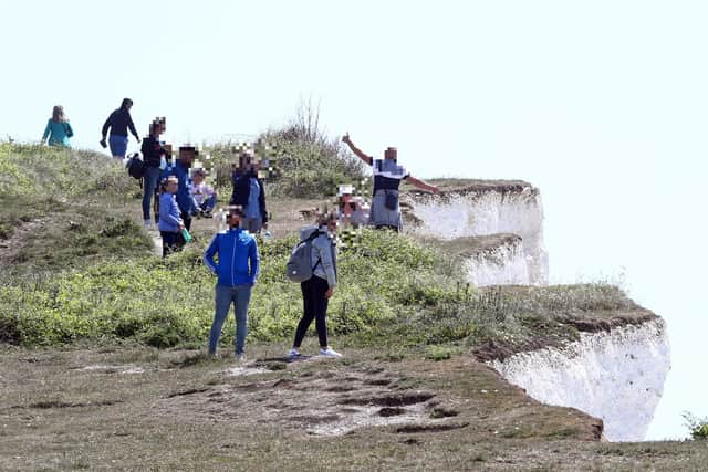 A man poses for a picture on the edge of dangerous cliffs at Birling Gap. Picture: Gareth Fuller/PA Wire