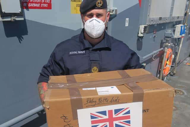 Chief Petty Officer Ash Head leads efforts to unload stores, including sanitary and baby products.