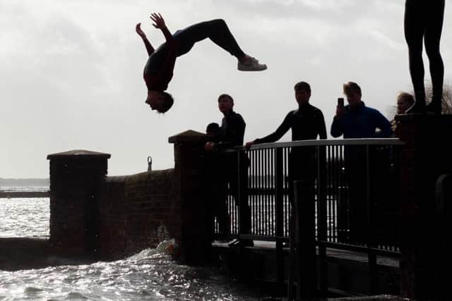 The males were backflipping into the sea as the coastguard issued a warning "in the strongest possible terms to stay away from the coast".