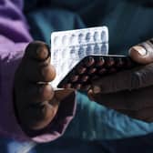 An HIV positive TB patient, holds a packet of tablets received as part of his treatment. Photo: Jekesai Njikizana/AFP via Getty Images