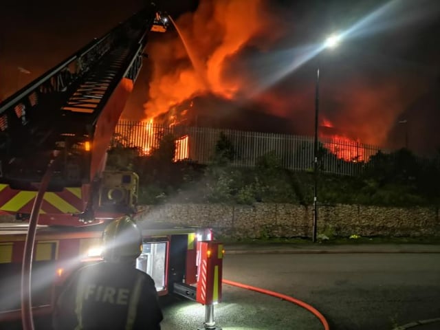 Fire crews pour water on the blaze using an aerial platform