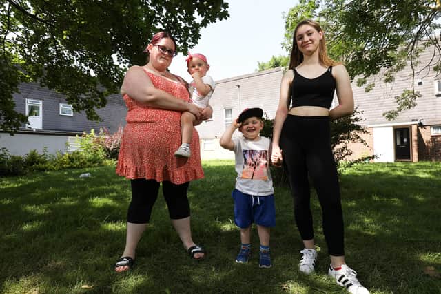 Lynsey Jackson holding Elsie, two, and her other children, Frank, three, and Lily, 15, pictured in Fratton. Following the death of her husband, Barry, from Covid-19 on Boxing Day, they would like to create a memorial garden in his honour. Picture: Chris Moorhouse (jpns 220721-46)