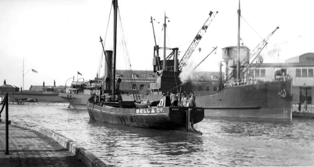A long gone scene at the Camber, Old Portsmouth.
With a collier tied up alongside the Camber dock we see a steam vessel making her way out to the harbour. Picture: Barry Cox collection