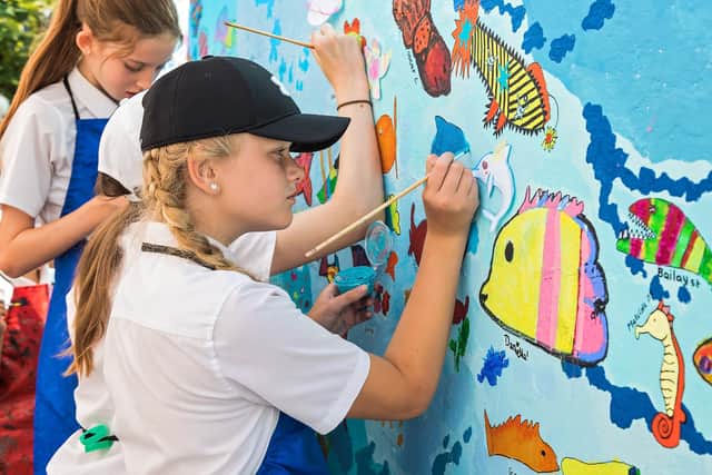 Evie (11) from Solent Road Juniors painting a dolphin on the wall at Hilsea Lido. Picture: Mike Cooter (200721)