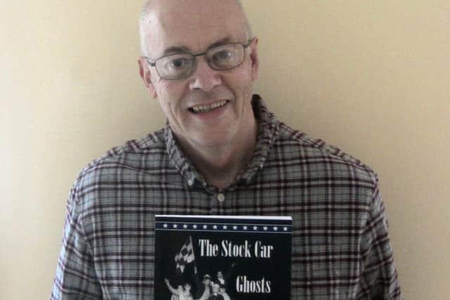 Steve Daily holding a copy of The Stock Car Ghosts