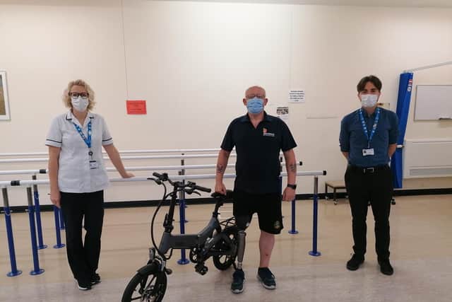 Amputee Derek Cassie (centre) withthe bike and staff from the  Portsmouth Enablement Centre. Picture: PHU