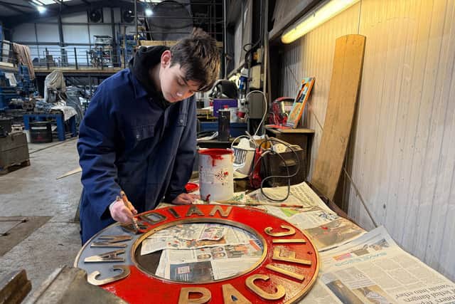 Volunteer Lucas Bell paints the Canadian Pacific nameplate