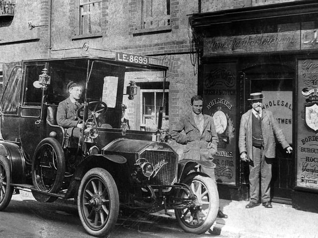 Chauffeurs waiting for guests outside the Bear Hotel, East Street, Havant. The Bear Hotel was built c.1747, according to the deeds of the property. The gentlemen next door are at a wholesale shop selling Irish and Scotch Whiskies, Champagnes, Bordaeux and Burgundies and Hocks.