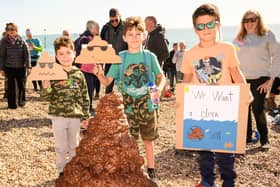 Pictured is: Habia, Hugo and Leo with their protest signs by a giant pretend pile of faeces 

Picture: Keith Woodland (081021-104)