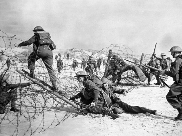 1940: British soldiers negotiating a barbed wire defence during a seashore invasion exercise.  (Photo by Hulton Archive/Getty Images)