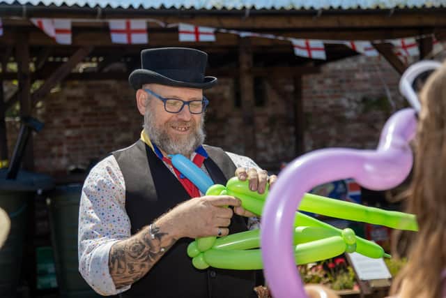 A party entertain shows off his balloon skills at Fort Cumberland 

Photos by Alex Shute