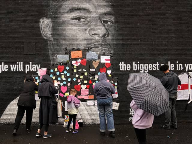 People place messages of support over offensive wording on the mural of Manchester United striker and England player Marcus Rashford on Copson Street, Withington, which appeared vandalised the morning after the England football team lost the UEFA Euro 2020 final, July 12, 2021. Picture: Martin Rickett/PA Wire.