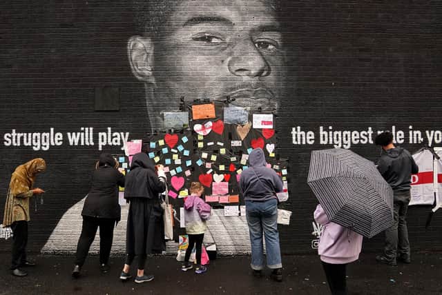 People place messages of support over offensive wording on the mural of Manchester United striker and England player Marcus Rashford on Copson Street, Withington, which appeared vandalised the morning after the England football team lost the UEFA Euro 2020 final, July 12, 2021. Picture: Martin Rickett/PA Wire.