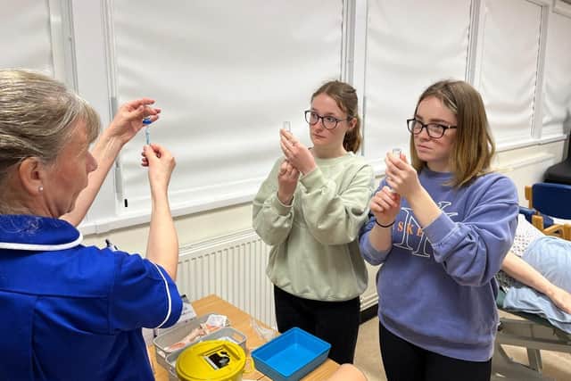 Students practise how to draw vaccine into a syringe