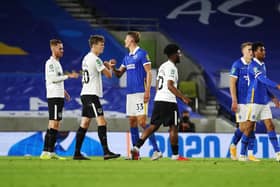 Pompey's Ellis Harrison and Portsmouth's Sean Raggett  after the defeat to Brighton. Picture: Joe Pepler