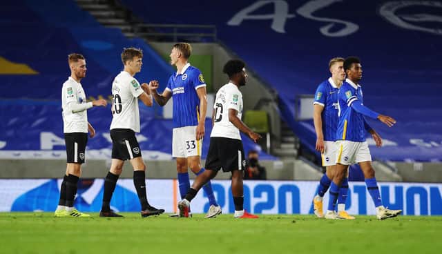 Pompey's Ellis Harrison and Portsmouth's Sean Raggett after the defeat to Brighton. Picture: Joe Pepler