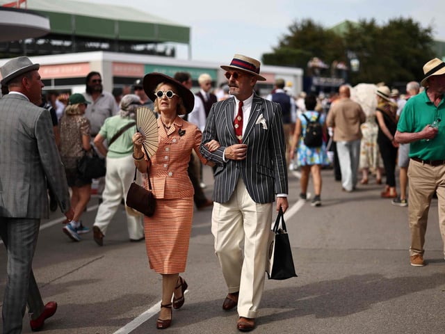 People wearing period clothing attend the opening day of Goodwood Revival at the Goodwood Motor Circuit in Chichester on September 8, 2023. The only historic motor race meeting to be staged entirely in a period theme, Goodwood Revival is an immersive celebration of iconic cars and fashion. (Photo by HENRY NICHOLLS / AFP) (Photo by HENRY NICHOLLS/AFP via Getty Images)