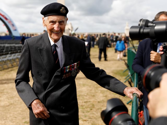 Former British Royal Marine, and D-Day veteran Jim Booth, reacts as he poses for a photograph