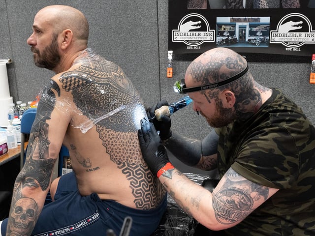 Pictured is: Jen Bradley tattoos Wayne Huggitt with an intricate pattern
Picture: Keith Woodland (010421-34)