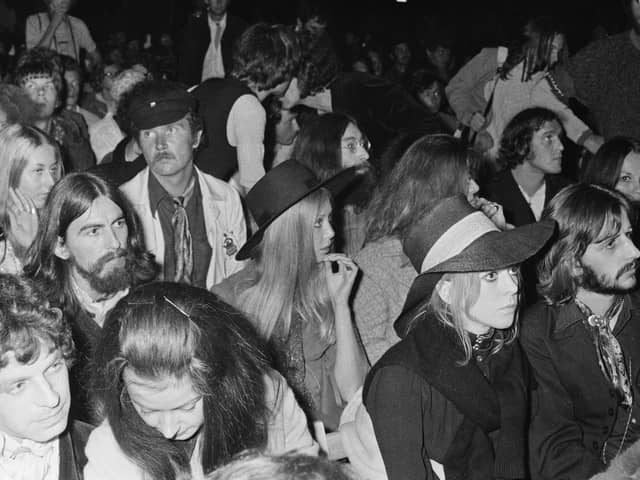 John Lennon, centre, George Harrison, left, and his wife, model, photographer and author, Pattie Boyd, and Ringo Starr, front, in the crowd at the 1969 Isle of Wight Festival. Picture: William Lovelace/Daily Express/Hulton Archive/Getty Images.