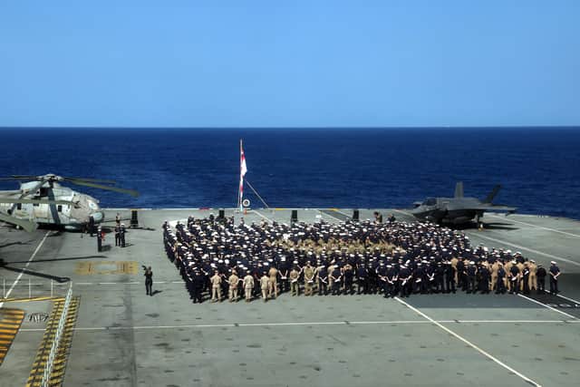 Handout photo issued by the Ministry of Defence (MoD) of the ships company and staff during a Remembrance Sunday service on the flight deck of HMS Queen Elizabeth, whilst on deployment with the Carrier Strike Group 21(CSG21) as part of Operation Fortis. Picture date: Sunday November 14, 2021.