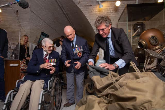 Pictured: John Payne with Ginge Fullen, middle, and Kevin Casey, right, looking at the diving equipment John wore in The Diving Museum, Gosport.     

Picture: Habibur Rahman