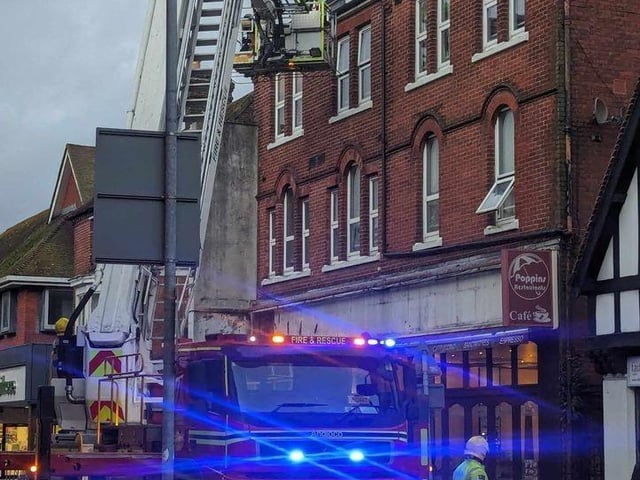 Firefighters fixing loose roof tiles and a sign above Poppins Cafe in North Street, Havant, on January 2.