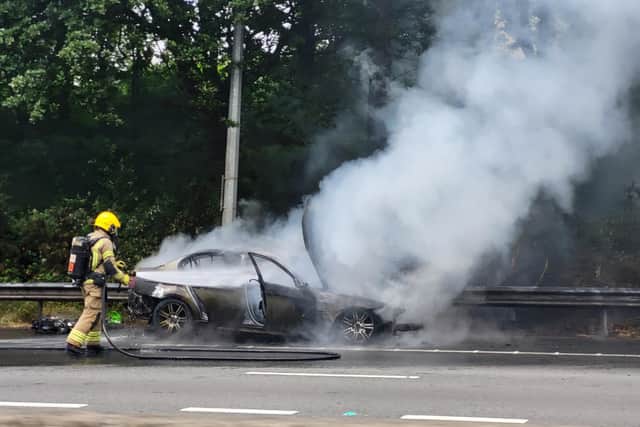 A firefighter tackles a blazing car between junctions 3 and 4 of the M27, June 24, 2022. Picture by Marc Hindley