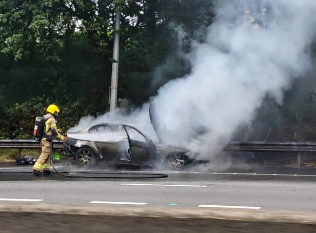 A firefighter tackles a blazing car between junctions 3 and 4 of the M27, June 24, 2022. Picture by Marc Hindley