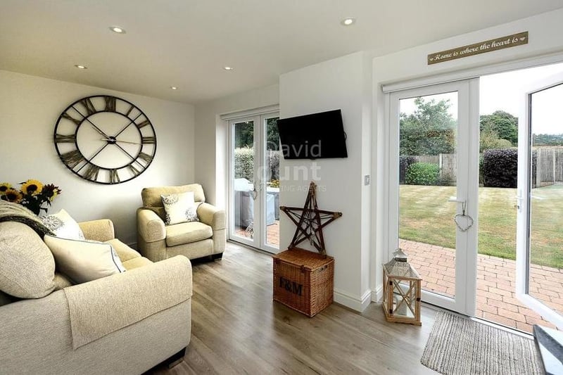 The kitchen includes this comfortable area in which to relax. Twin French doors lead to the back garden.