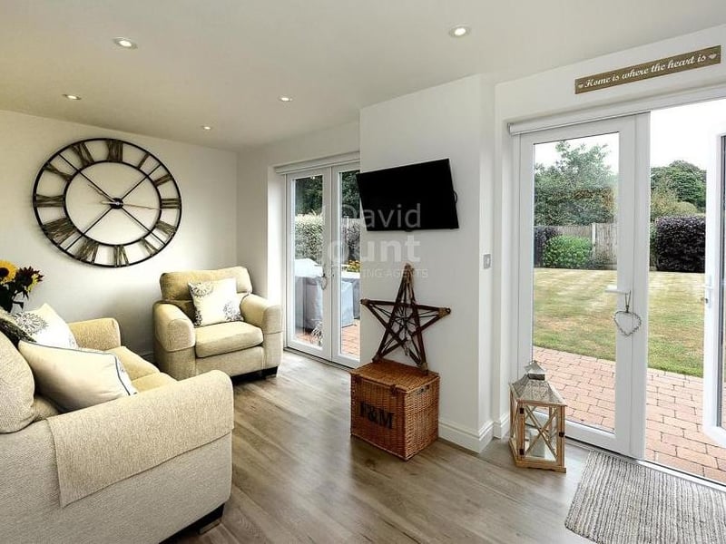 The kitchen includes this comfortable area in which to relax. Twin French doors lead to the back garden.