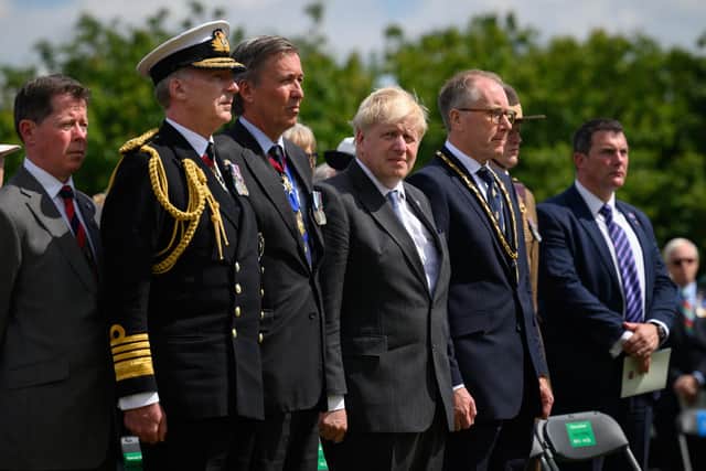 Britain's Prime Minister Boris Johnson (C) stands with military dignitaries before addressing veterans and family members during a memorial event to mark the 40th anniversary of the Falklands War at The National Memorial Arboretum on June 14, 2022 in Stafford, England. Photo by Leon Neal - WPA Pool/Getty Images