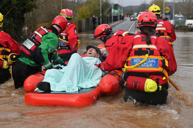 Mountain Rescue team members rescue Peter Morgan from his house where he has lived his whole life, which has been flooded in Monmouth, in the aftermath of Storm Dennis. Pic: Ben Birchall/PA Wire