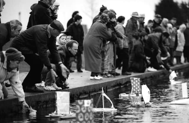 Competitors urge their boats on at the launch of the 1996 Gosport Model Yacht and Boat Club paper boat race.