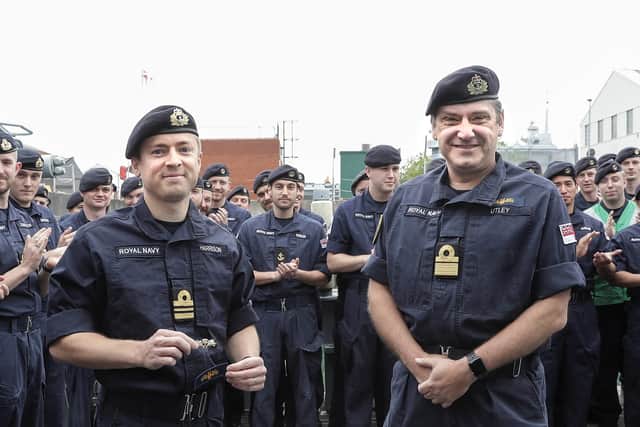 Rear Admiral Mike Utley, pictured with HMS Chiddingfold's captain, Lieutenant Commander Tom Harrison, left, with crew in the background. Photo: Royal Navy