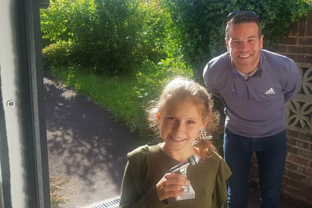 Keen performer Mia Lintott, 10 from Lovedean, has been singing a song every day for 100 days to cheer people up during lockdown. Pictured: Mia with Mark Harris, who awarded her a trophy and has offered her a free session in his recording studio
