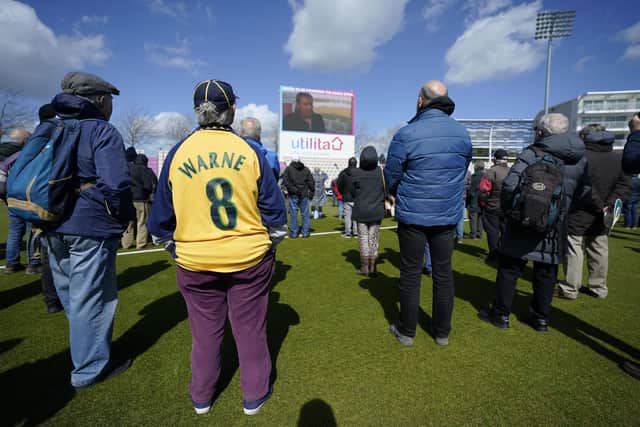 Spectators take to the field of play during the lunch break to watch a tribute to Shane Warne on the giant TV screen during day one of the LV= County Championship Division One match at The Ageas Bowl. Picture: Andrew Matthews/PA Wire.