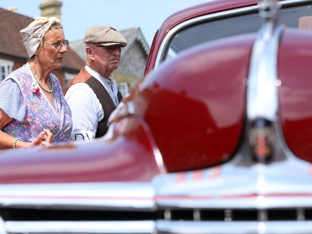 Re-enactors Elaine Sparrow and Terry Lemmon admire a 1942 Dodge.