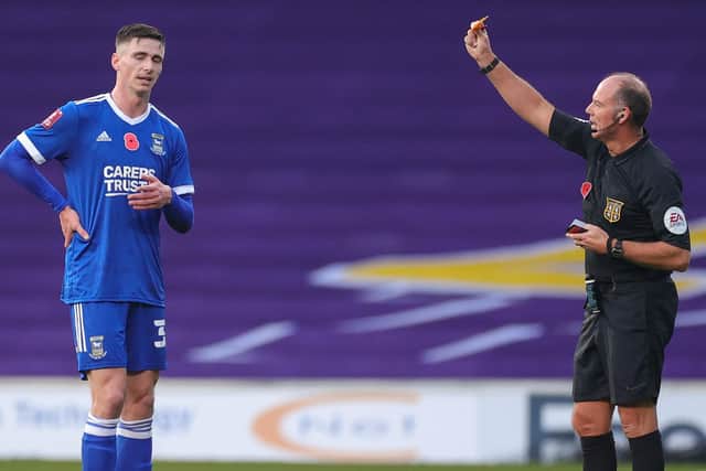 Former Pompey striker Oli Hawkins receives a yellow card following a foul on Rasmus Nicolaisen