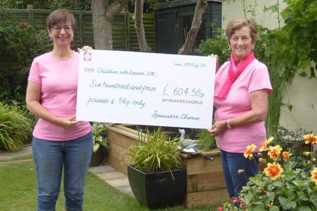 Choir members, Jill Cook (left) and Diana Carver holding the presentation cheque.