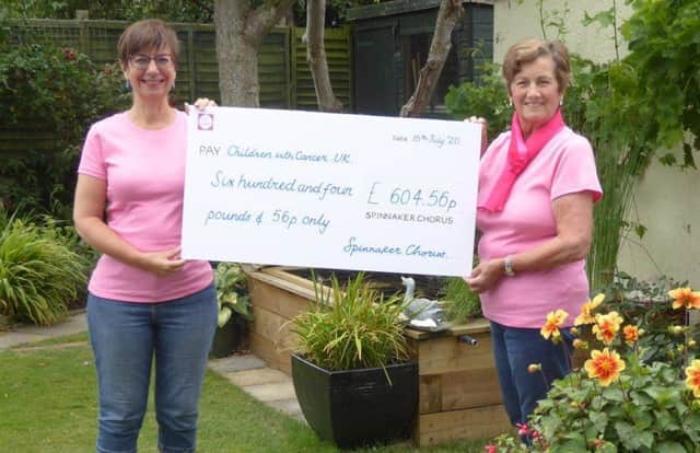 Choir members, Jill Cook (left) and Diana Carver holding the presentation cheque.