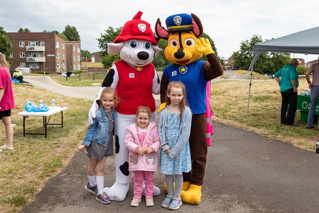 Sisters Katie Payne (7), Isabelle Payne (3) and Amelia Payne (8) with some of the friendly characters at the Party in the Warren. Picture: Mike Cooter (080723)