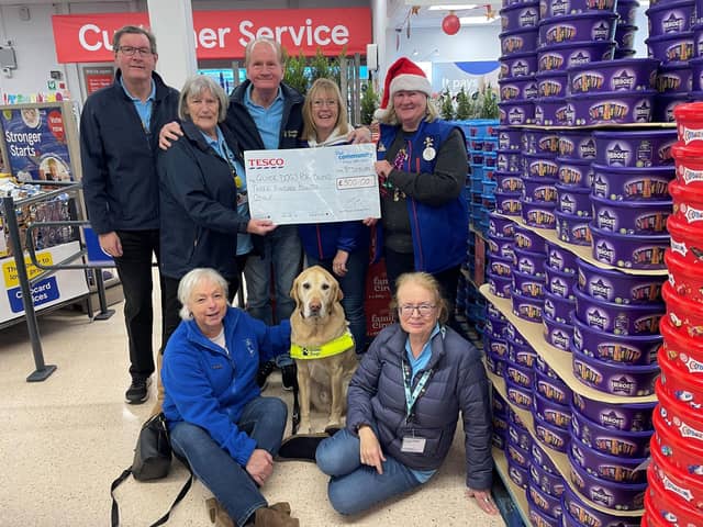 Friends fur-ever: Tesco colleagues present Guide Dogs volunteers with essential funding.