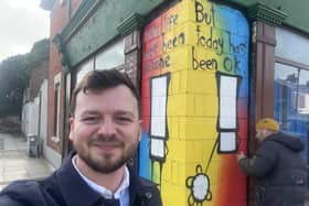 Portsmouth City Council candidate Joshua Allen poses in front of My Dog Sighs' latest creation. Picture: Contributed