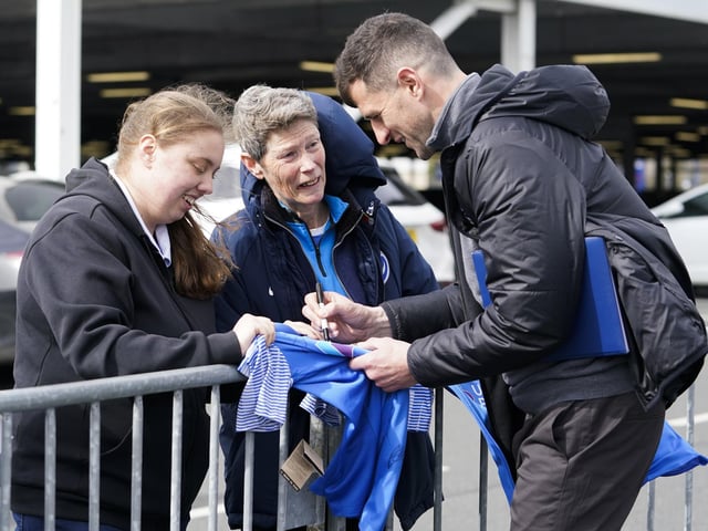 John Mousinho stops to sign autographs for more well-wishers before the game