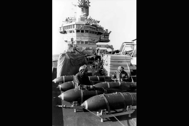 Hms Hermes bomb preparation May 27th 1982Armourers of 800 Naval Air Squadron (sea harrier) prepare 1000 lb bombs for use, on the flight deck of HMS Hermes, during the Falklands Conflict. Picture: Martin Cleaver, aboard HMS Hermes/PA.