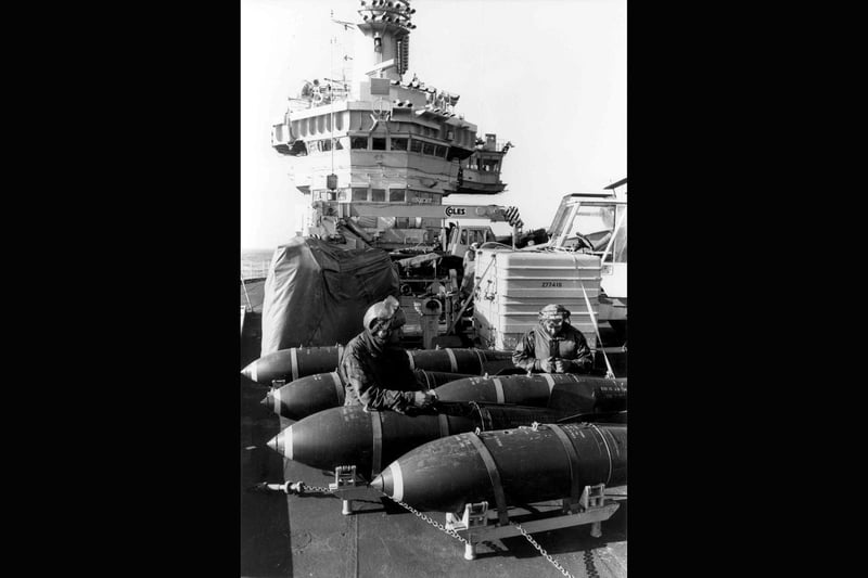 Hms Hermes bomb preparation May 27th 1982 Armourers of 800 Naval Air Squadron (sea harrier) prepare 1000 lb bombs for use, on the flight deck of HMS Hermes, during the Falklands Conflict. Picture: Martin Cleaver, aboard HMS Hermes/PA.