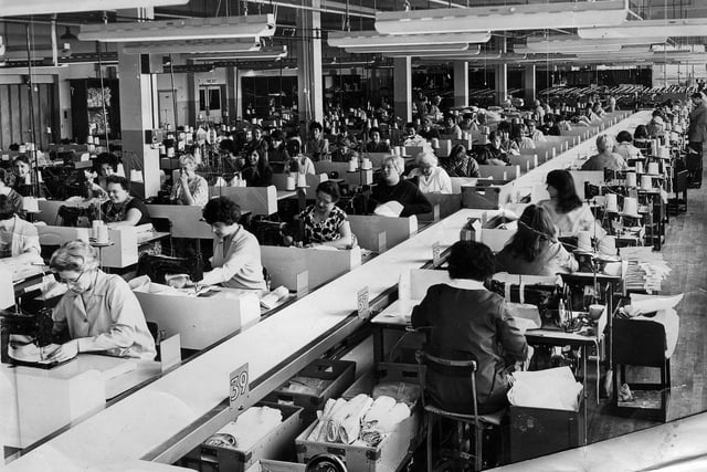 The Twilfit corset factory shop floor, at the Industrial estate, Farlington Marsh, Portsmouth in 1968 with Yvonne Buist  in the third row of machinists from the left in front of a pillar in the centre of the picture