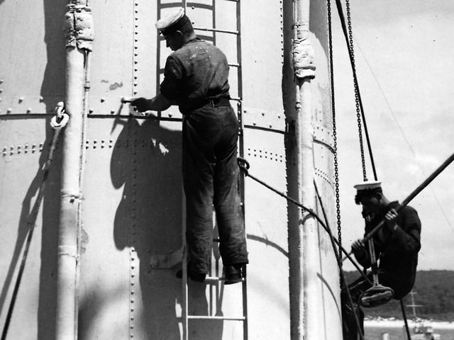 HMS Sussex crew on paint shop duties.A laborious job from the past here we see some of the crew of HMS Sussex on paint ship duties circa 1930s. Pic: Andrew August collection.
